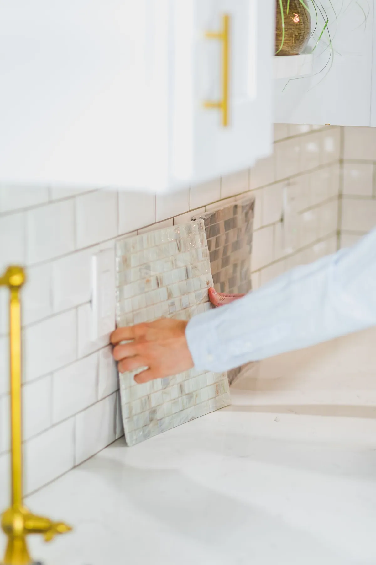 Comparing tile samples against a kitchen backsplash